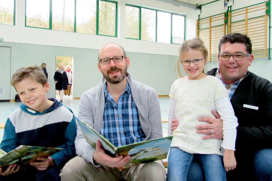 Sie sind Fans der frechen Kuh Lieselotte – v.l. Linus, Illustrator Alexander Steffensmeier, Maresa sowie Vater und Bücherbus-Mitarbeiter Andy Schulte.  Bildnachweis: Kreisfahrbücherei Paderborn, Nina Gilbert